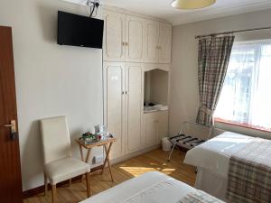 1 dormitorio con 1 cama, armario y silla en Cois Farraige, en Lahinch