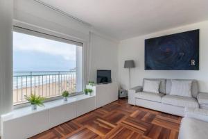 a living room with a white couch and a large window at Bakio Beach in Bakio