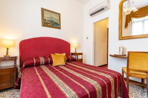 a bedroom with a large bed with a red headboard at Palazzo Schiavoni Residenza d'epoca in Venice