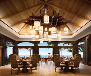 ein Esszimmer mit Tischen, Stühlen und einem Kronleuchter in der Unterkunft Four Seasons Resort Lana'i in Lanai City