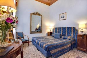 a bedroom with a bed and a table and a mirror at Palazzo Schiavoni Residenza d'epoca in Venice