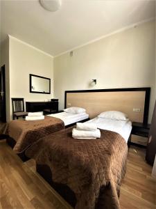 a hotel room with two beds and two lamps at Hotel Koral in Chernivtsi