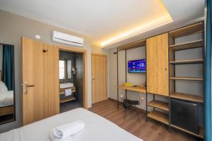 a bedroom with a bed and a desk and a television at Çorlu Dem Hotel in Corlu