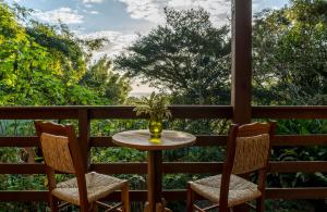 a table and two chairs on a porch with a view at Coração da Terra Praia do Rosa in Praia do Rosa +196 photos