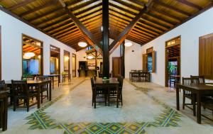 a dining room with wooden tables and chairs at Pousada Vila do Beco in Arraial d'Ajuda