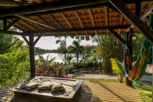 a patio with a hammock and a view of a lake at Coração da Terra Praia do Rosa in Praia do Rosa