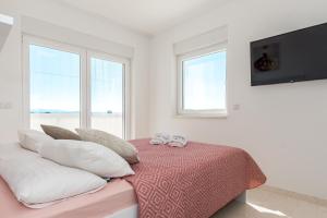 a bedroom with a bed with pillows and a television at Villa Buzuk in Vodice