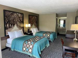 a hotel room with two beds and a desk at Super 8 by Wyndham Elberton in Elberton