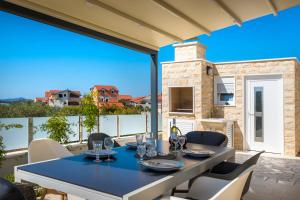 a dining room with a table and chairs on a patio at Villa Buzuk in Vodice