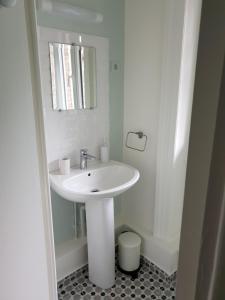 Baño blanco con lavabo y espejo en MANOIR D’ AVRAY, en Saint-Just-dʼAvray