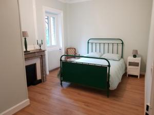 1 dormitorio con cama verde y chimenea en MANOIR D’ AVRAY, en Saint-Just-dʼAvray
