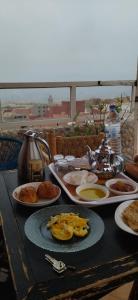 een tafel met daarop borden met eten bij Chambre Surf Oubaha Tamrakht Taghazout in Agadir