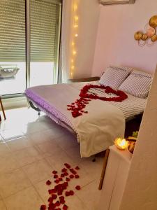 ein Bett mit roten Rosen auf dem Boden in einem Zimmer in der Unterkunft L’IODE MARINE in La Ciotat