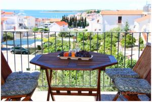 een tafel met een schaal fruit op een balkon bij Primosten Apartments in Primošten