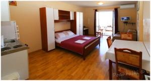 een slaapkamer met een bed en een keuken met een tafel bij Primosten Apartments in Primošten