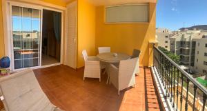 uma varanda com uma mesa e cadeiras. em Well refined apartment - stunning pool em Palm-mar