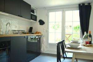 a kitchen with a table with chairs and a window at Les Grumes, Centre Ville, Jardin,Self check-in, FreeWifi, Netflix in Compiègne