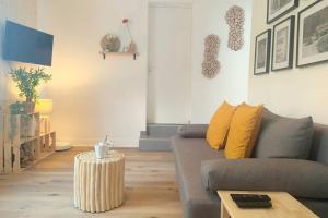 ein Wohnzimmer mit einem Sofa und einem Tisch in der Unterkunft Les Grumes, Centre Ville, Jardin,Self check-in, FreeWifi, Netflix in Compiègne