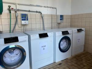 a laundry room with three washing machines in it at Hotel Toscana in Interlaken