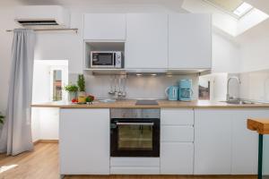 a kitchen with white cabinets and a counter top at San Pietro apartment in Dubrovnik