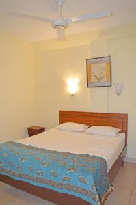 ein Schlafzimmer mit einem Bett mit einer blauen Decke darauf in der Unterkunft Maurer Loisirs Ltee in Trou aux Biches
