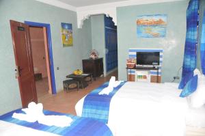una camera d'albergo con due letti e una televisione di Riad Mhidou a Marrakech