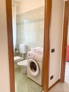 ein Badezimmer mit einer Waschmaschine und einem WC in der Unterkunft La casa di Paola in Solesino