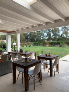 un patio con mesas y sillas bajo toldo en Mabell Guest House, en Civitavecchia