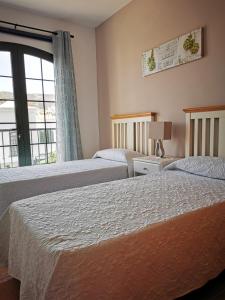 two beds in a hotel room with a window at Cosy duplex in Agaete with WIFI in Agaete