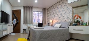 una camera con un grande letto e una TV di Flat da Vila a Viçosa do Ceará