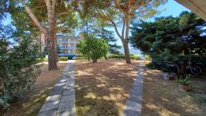 Luni的住宿－appartamento mare di Luni Mare，一座种有树木的花园,一座建筑的背景