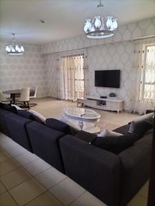 a living room with a couch and a tv at Elan Rimal2 Suites in Dubai