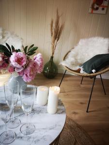 Charmant duplex 80m² في Mouchard: طاولة مع كؤوس النبيذ والزهور والشموع