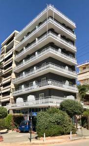 un grande condominio con un'auto parcheggiata di fronte di Arma Faliro Apartments ad Atene