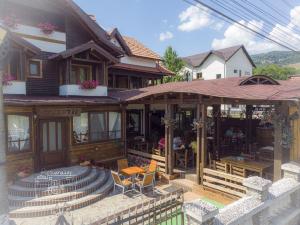 a house with a porch and a patio at Pensiunea Bella Vista in Arefu