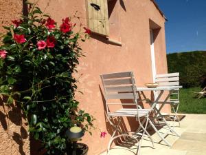 two chairs and a table next to a building with flowers at Chez Calou in Mane
