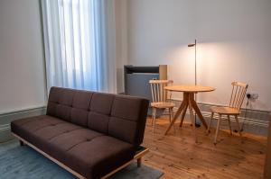 sala de estar con sofá, mesa y sillas en Cravo’s Heritage House, en Pinhel
