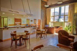 a living room with tables and chairs and a bar at Melewe Apart hotel Caviahue in Caviahue