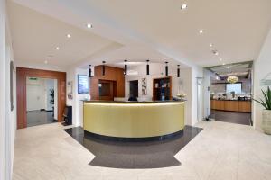 a lobby with a yellow bar and a kitchen at Hotel Engel in Zofingen