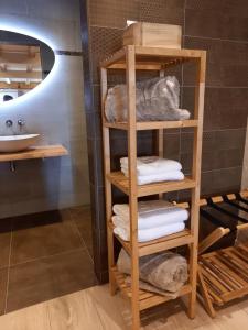 een houten handdoekenrek in de badkamer met handdoeken bij Suite Pura Vida in Oud-Ade