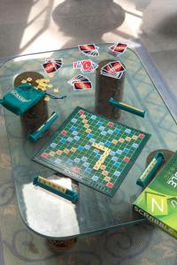 uma mesa de vidro com um jogo de tabuleiro em cima em SaffronStays Thalassea, Alibaug - picturesque sea-facing villa with colonial decor em Alibag