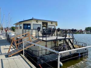 a house boat docked at a dock in the water at Island-dreams Hausboote Groth & Rhin in Schleswig