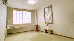 a room with a window and a vase of flowers on a table at 大同GardenHotel 大阪西九条 本館 in Osaka +24 photos