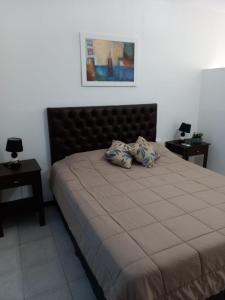 - une chambre avec un grand lit et 2 tables de chevet dans l'établissement Departamento Centro, à La Rioja