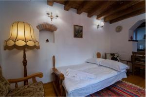 1 dormitorio con 1 cama con lámpara y silla en Casa Lörinczi, en Sighişoara