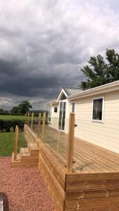 a wooden deck in front of a house at Hesket caravan park Plot Number 7 STRICTLY NOT FOR COMMERCIAL USE in High Hesket