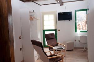 ein Wohnzimmer mit 2 Stühlen und einem TV in der Unterkunft Casa Catuja in Los Realejos