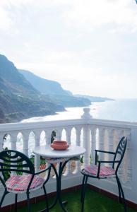 einen Tisch und Stühle auf einem Balkon mit Meerblick in der Unterkunft Casa Catuja in Los Realejos