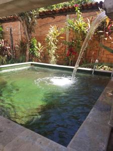 a swimming pool with a water fountain at Pouso Vovó Laurinda in Pirenópolis