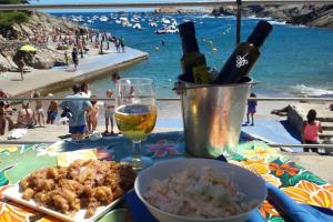 una mesa con un plato de comida y vino en una playa en APT. CON VISTAS ISLAS MEDAS, en Girona